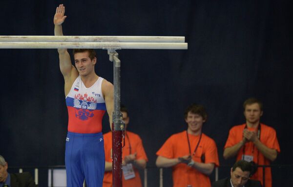 Российский гимнаст Давид Белявский выполняет упражнение на брусьях