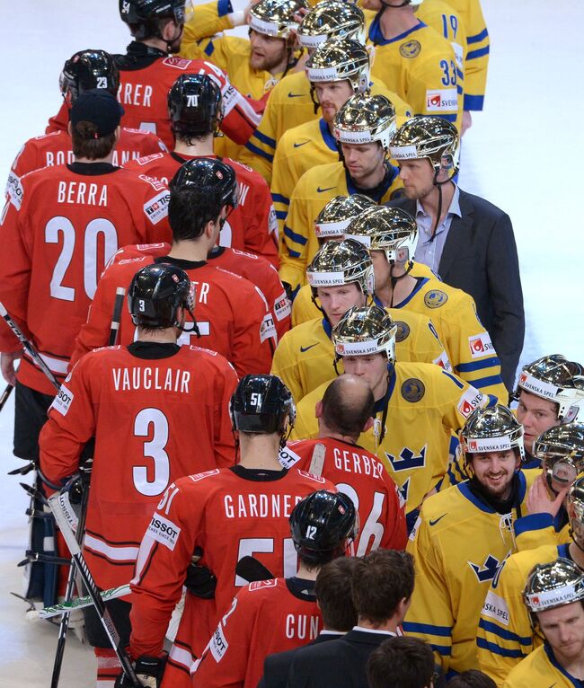 Хоккеисты сборной Швейцарии (слева) и хоккеисты сборной Швеции после финального матча