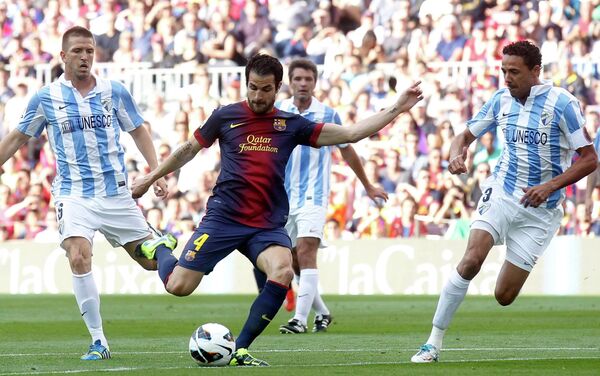 Полузащитник Барселоны Сеск Фабрегас забивает мяч в ворота Малаги