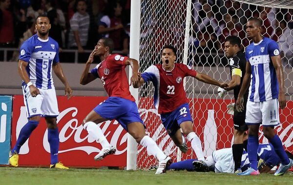Защитник сборной Коста-Рики Рой Миллер забивает мяч в ворота сборной Гондураса
