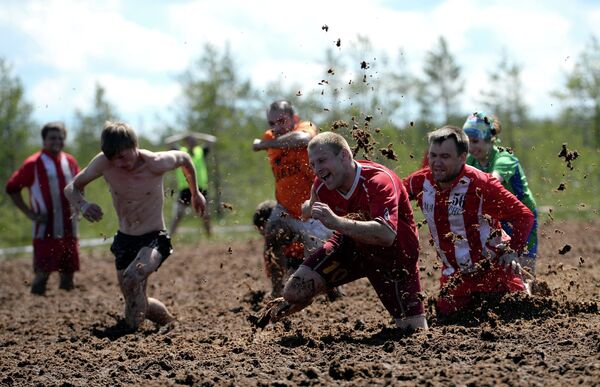 Участники чемпионата России по футболу в грязи около деревни Поги