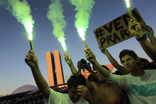 Демонстранты зажигают файеры в знак протеста против затрат на Кубок Конфедераций по футболу и политики президента страны Дилмы Русеф в столице страны - Бразилии