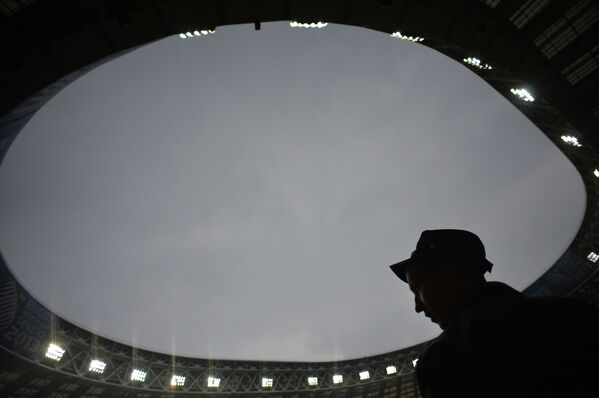 Сотрудник полиции следит за безопасностью на стадионе Лужники во время сильного дождя