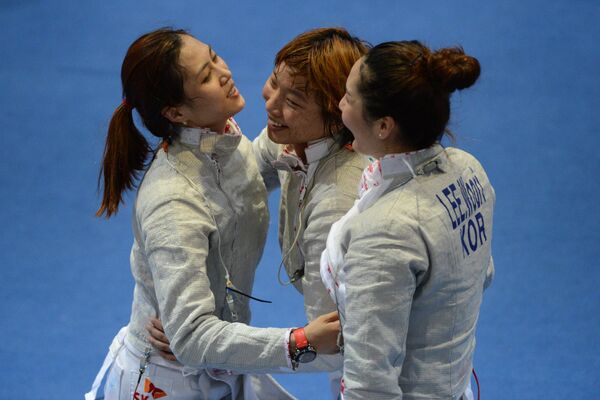 Корейские спортсменки Ким Джи Йон, Ли Расон и Ли Ву Ри после победы в финальном поединке по фехтованию на саблях