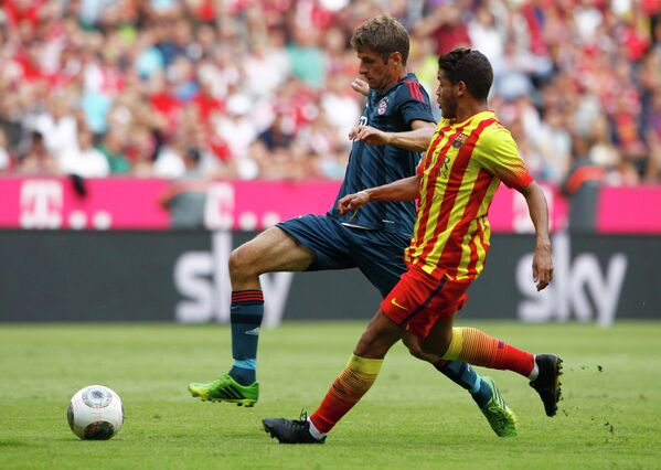 Игрок ФК Барселона Джонатан дос Сантос (на переднем плане) и игрок ФК Бавария Томас Мюллер