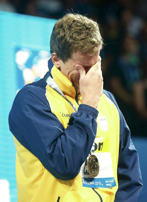 Победитель заплыва на 50 метров бразилец Сезар Фильо плачет во время церемонии награждения