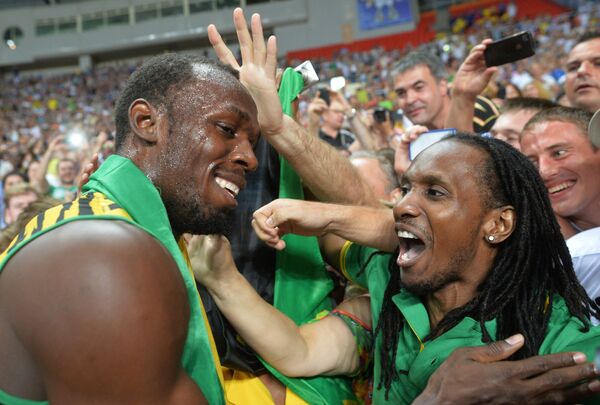 Ямайский спортсмен Усэйн Болт (слева)