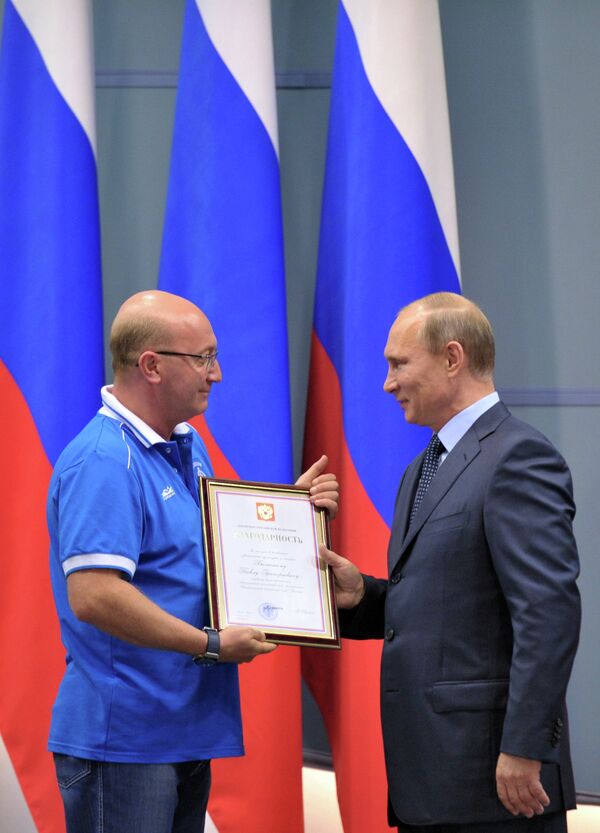 Президент России Владимир Путин (справа) вручает благодарственную грамоту первому вице-президенту клуба Динамо Павлу Бальскому