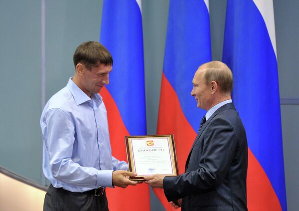 Президент России Владимир Путин (справа) вручает благодарственную грамоту заслуженному мастеру спорта Константину Горовикову