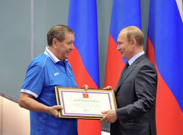 Президент России Владимир Путин (справа) вручает почетную грамоту советнику президента клуба Динамо Александру Мальцеву
