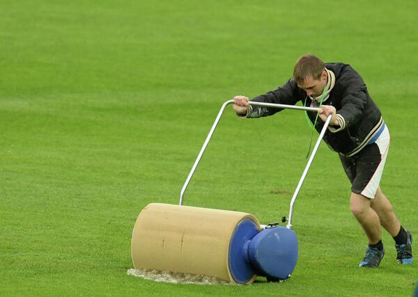 Работник стадиона убирает воду с футбольного поля перед матчем отборочного тура Чемпионата мира-2014 между сборными командами России и Люксембурга