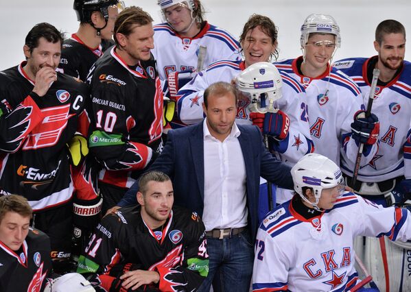 Хоккеист Максим Сушинский (в центре) вместе с хоккеистами СКА и Авангарда позируют фотографам после окончания матча.