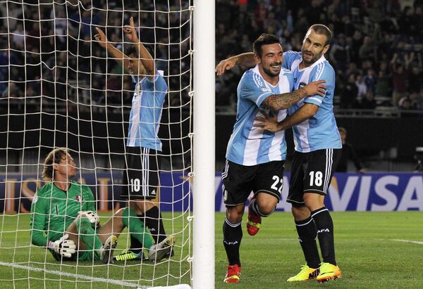 Футболисты сборной Аргентины Серхио Агуэро и Родриго Паласио поздравляют с забитым мячом Эсекьеля Лавесси