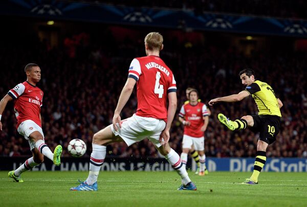 Форвард дортмундской Боруссии Генрих Мхитарян забивает мяч в ворота Арсенала