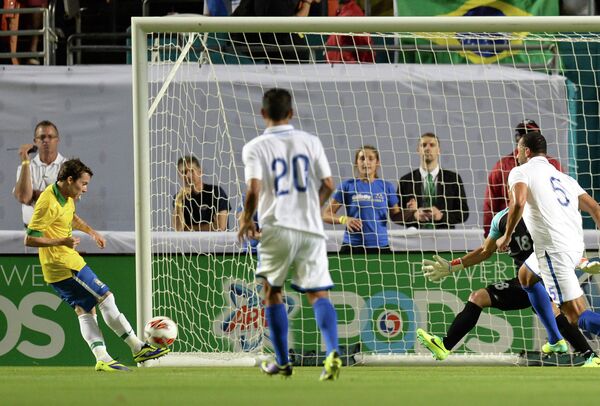 Нападающий сборной Бразилии Бернард забивает мяч в ворота сборной Гондураса