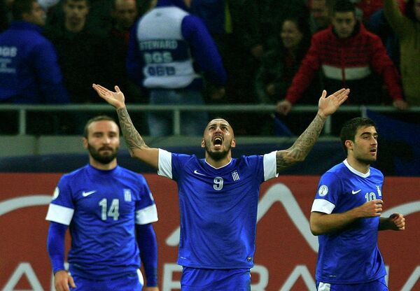 Нападающий сборной Греции Костас Митроглу радуется забитому мячу в ворота румын