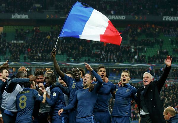 Футболисты сборной Франции вместе с главным тренером Дидье Дешамом радуются после победы над украинцами и выхода на чемпионат мира 2014 года