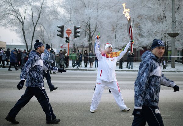 Факелоносец во время эстафеты олимпийского огня в Абакане в республике Хакасия