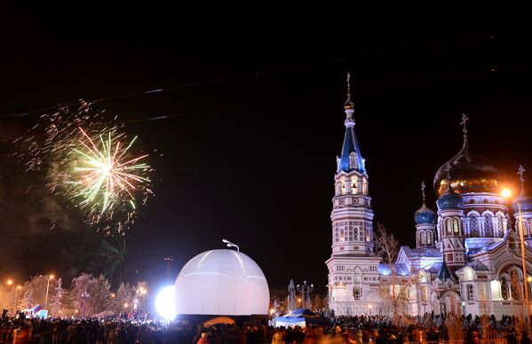 Зрители смотрят салют на торжественной церемонии зажжения чаши олимпийского огня в Омске