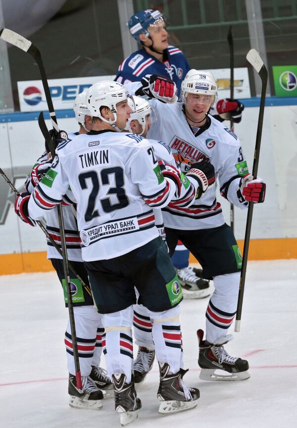 Хоккеисты Металлурга Евгений Тимкин (второй слева) и Денис Платонов (справа)