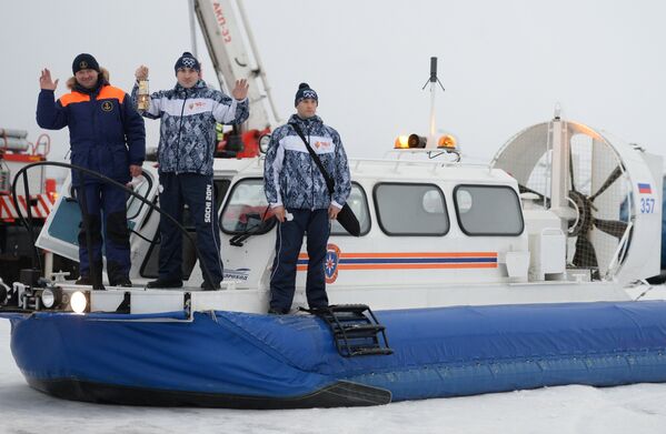 Хранители огня на судне на воздушной подушке во время эстафеты олимпийского огня в Казани