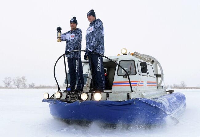 Хранители огня на судне на воздушной подушке во время эстафеты олимпийского огня в Болгаре