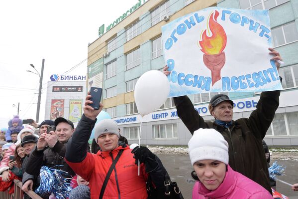 Жители Нижнего Новгорода наблюдают за эстафетой олимпийского огня на проспекте Ленина