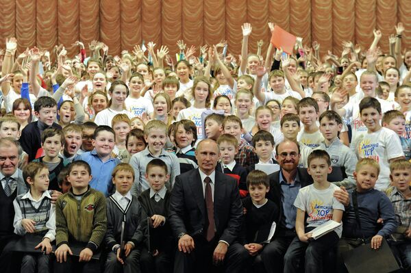 Президент России Владимир Путин (в центре) фотографируется с участниками Сводного детского хора России