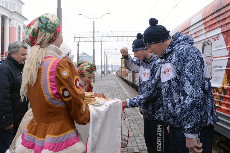 Мэр Саранска Петр Тултаев (слева на втором плане) встречает хранителей олимпийского огня на железнодорожном вокзале в Саранске