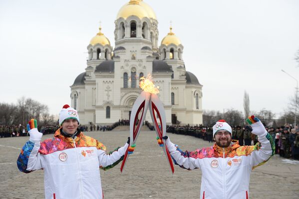 Факелоносец Денис Письменный (слева) во время эстафеты олимпийского огня в Новочеркасске