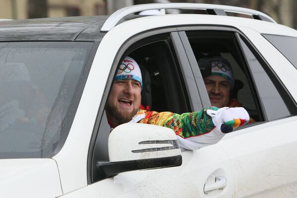 Рамзан Кадыров за рулем автомобиля сопровождает факелоносцев.