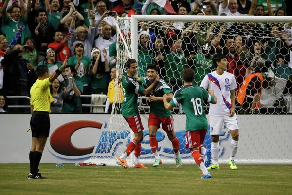 Полузащитник сборной Мексиси Алан Пулидо (в центре) радуется забитому мячу в ворота южнокорейцев