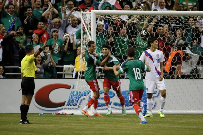 Полузащитник сборной Мексиси Алан Пулидо (в центре) радуется забитому мячу в ворота южнокорейцев