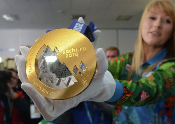 Светлана Журова демонстрирует журналистам золотую медаль