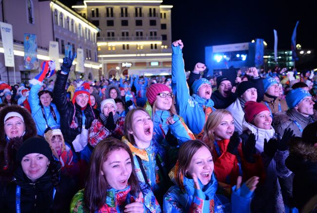 Зрители смотрят трансляцию церемонии открытия в прямом эфире на площади Роза Хутор