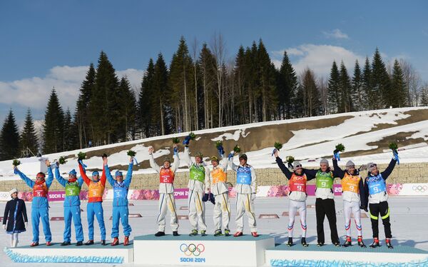 Призеры эстафеты в соревнованиях по лыжным гонкам среди мужчин на XXII зимних Олимпийских играх в Сочи во время цветочной церемонии