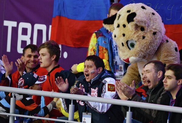 Талисман ХХII Зимних Олимпийских Леопард и болельщики наблюдают за матчем