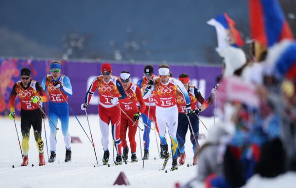 Спортсмены на дистанции финального забега командного спринта в соревнованиях по лыжным гонкам