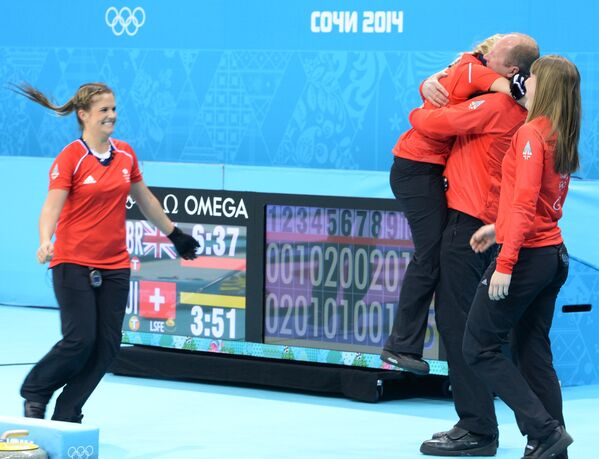 Слева направо: Вики Адамс (Великобритания), Анна Слоун (Великобритания) и тренер Дэвид Хэй (Великобритания) радуются победе в матче за третье место между сборными командами Великобритании и Швейцарии в соревнованиях по керлингу среди женщин на XXII зимних Олимпийских играх в Сочи.