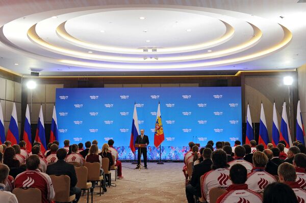 Президент России Владимир Путин (в центре на дальнем плане) во время церемонии награждения российских призеров XXII зимних Олимпийских игр в Сочи