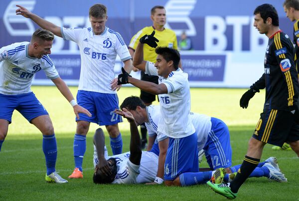Защитник Динамо Кристофер Самба (в центре) получает травму