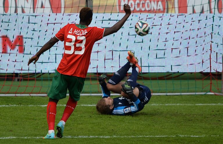 Нападающий Локомотива Даме Н'Дойе (слева) забивает мяч в ворота голкипера Урала Николая Заболотного