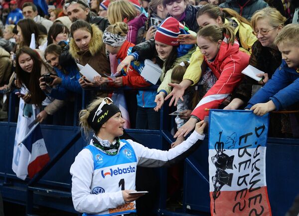 Мари Дорен-Абер (Франция) раздает автографы после окончания эстафетной гонки в соревнованиях среди смешанных команд на Гонке чемпионов 2014