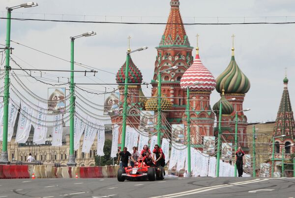 Болид команды Marussia F1 Team на шоу Moscow City Racing выкатывают с трассы в боксы