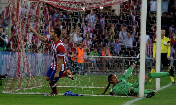 Нападающий Атлетико Коке забивает мяч в ворота Барселоны