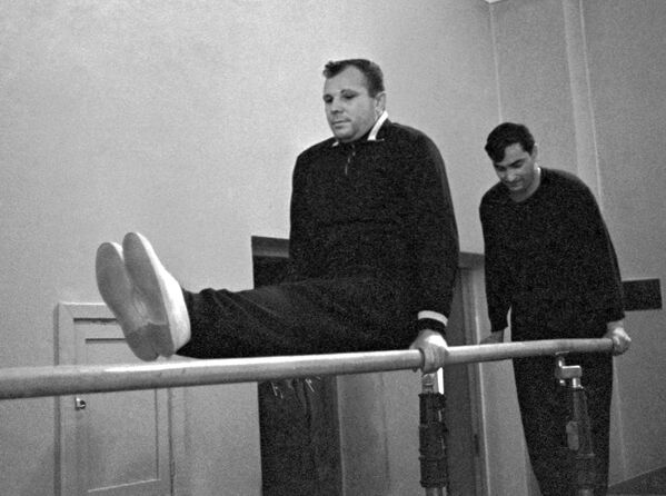 Космонавты Юрий Гагарин и Валерий Быковский делают упражнения на перекладине