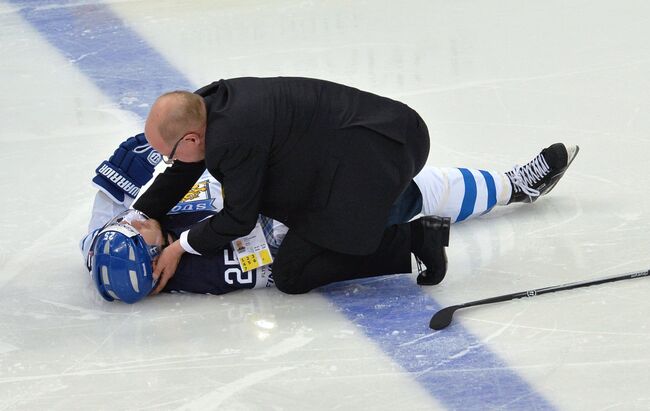 Врач оказывает первую помощь игроку сборной Финляндии Пекке Йормакку