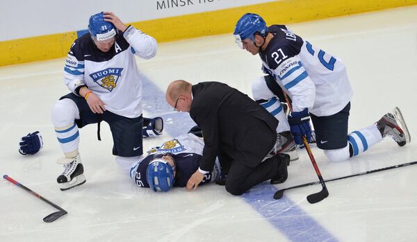 Врач оказывает первую помощь игроку сборной Финляндии Пекке Йормакку (в центре)