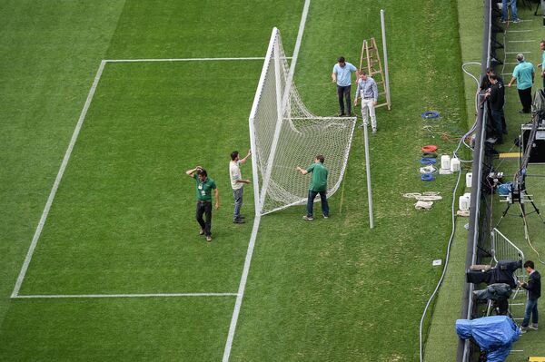 Сотрудники стадиона устанавливают ворота на поле стадиона Арена Коринтианс в Сан-Паулу