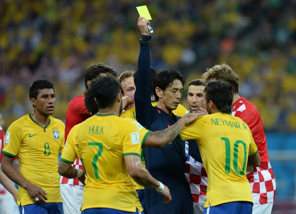 Главный судья матча Юити Нисимура показывает желтую карточку форварду сборной Бразилии Неймару